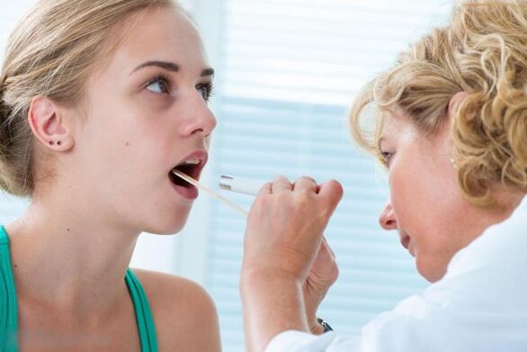 Ο γιατρός εξετάζει τη στοματική κοιλότητα για την παρουσία θηλωμάτων